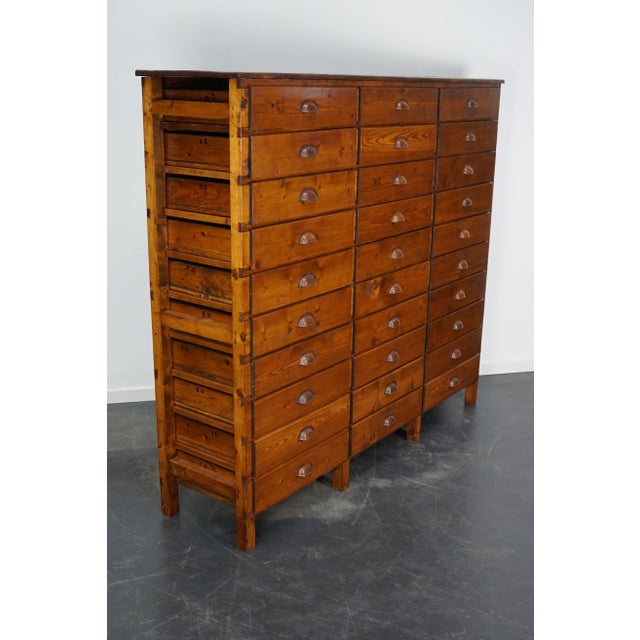 This apothecary cabinet was designed and made from pine. Circa 1950 in the Netherlands. It features 30 decent sized...