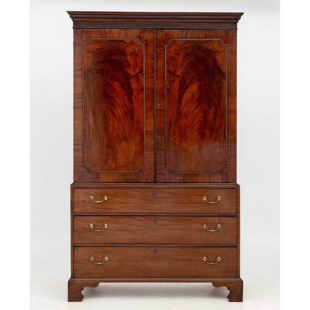 Edwardian Flame Mahogany Linen Press, the upper piece opening to storage compartment and the lower portion with three...