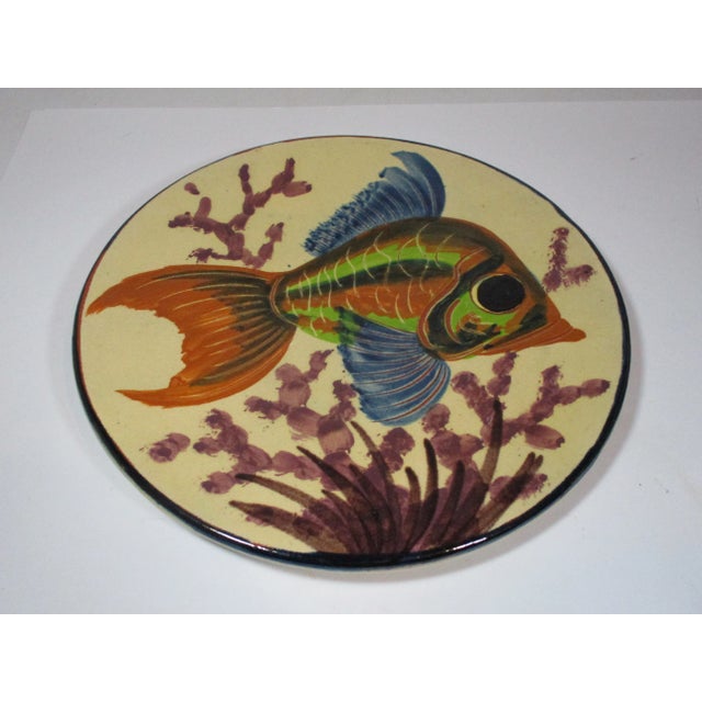 A large hand made and painted pottery decorative plate, made in Spain. It is decorated with a tropical fish in shades of...
