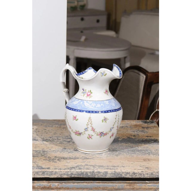 An English Booth's silicon China cameo pattern pitcher from the early 20th century, with pink roses and blue and white...