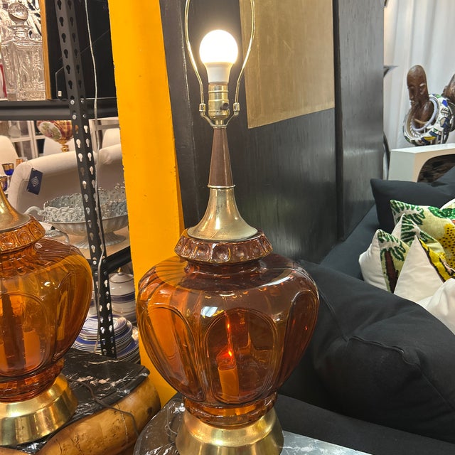 Large and impressive golden amber glass lamps with wood and brass necks and brass bases. The glass on both lamps is in...