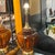 Large and impressive golden amber glass lamps with wood and brass necks and brass bases. The glass on both lamps is in...