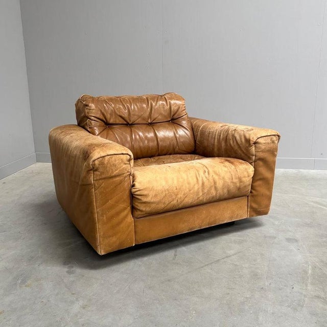 Mid century lounge chair by De Sede. Design by Robert Haussmann, Switzerland 1970s. Wooden frame with cognac leather...