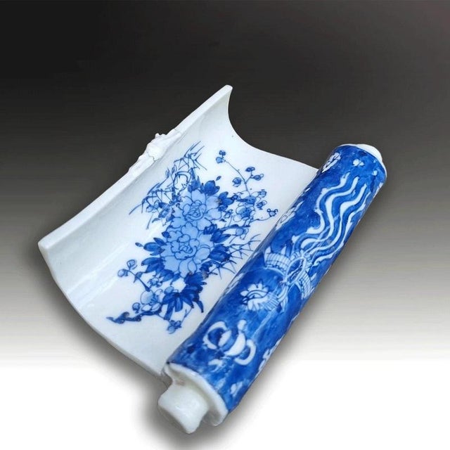 A rare Japanese Seto porcelain scholar's brush holder formed as a scroll and decorated in underglaze blue and white....