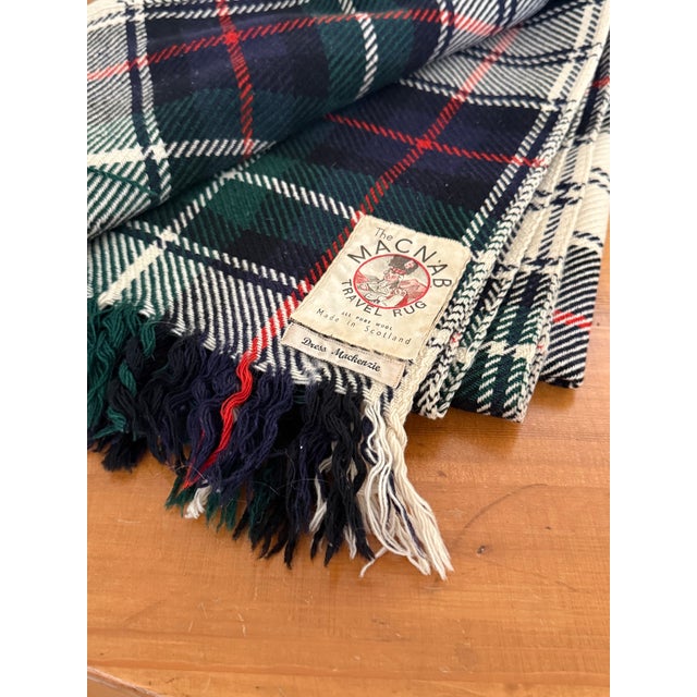The Macnab travel rug, aka throw blanket. Made in Scotland in the traditional white-based tartan pattern of Clan...