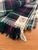 The Macnab travel rug, aka throw blanket. Made in Scotland in the traditional white-based tartan pattern of Clan...
