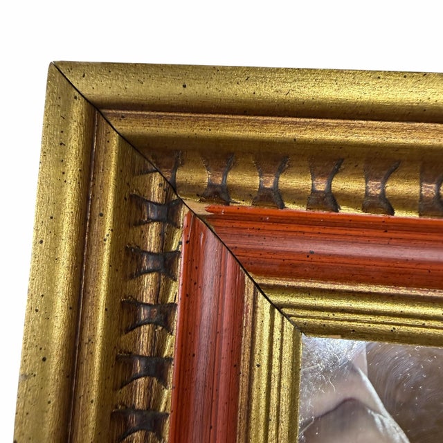 Vintage c. 1970s gold egg and dart frame wall mirror accented by burnt orange inner band. Frame measures 12.5” w x 1.25” d...