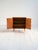 Teak cabinet with clean lines, raised on tapered legs and featuring hinged doors. This Scandinavian cabinet from the...