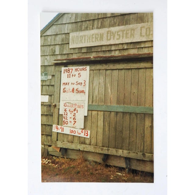 1987 color photograph on paper of the Northern Oyster Co. Hand painted signs showing prices. Unsigned. Unframed.