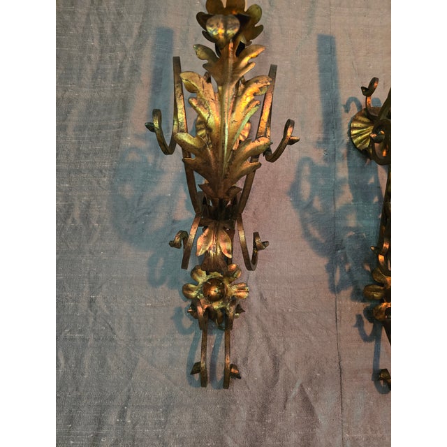 A rare vintage original pair of Italian mid century gilded pair of sconces. Having all hand made construction with an...