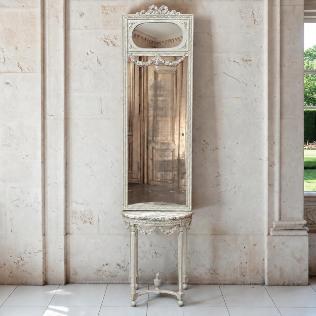 An antique Italian Louis XVI console with its matching trumeau mirror, carrying all the grace of neoclassicism in its...