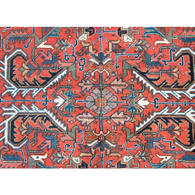 A wonderful early 20th century Persian Heriz rug with a large-scale mirrored floral and leaf pattern woven in tradition...