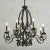 A 1920s French patinated iron chandelier with curved detailing. This chandelier has eight scalloped bobeches and new...