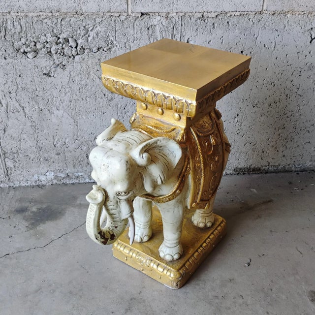 Enhance your space with this intricately hand-painted ceramic elephant stool. Its white and gold Hollywood regency accents...