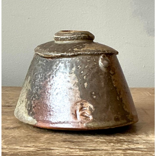 Embrace the elemental beauty of the studio pottery movement with this evocative vintage stoneware vase. Sculpted in a...