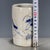 A charming Chinese blue and white porcelain brush pot (bitong). The cylindrical vessel features a creamy, all-over crackle...