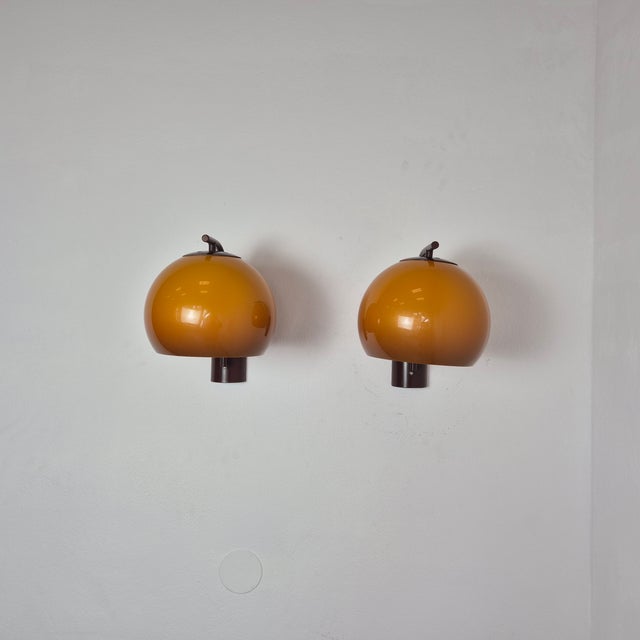 A pair of wall sconces by Szarvasi from the 1970s, designed in the distinctive Space Age aesthetic of the era. The amber...