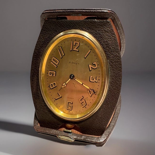 This listing is for an antique Swiss travel or desk clock. This one is by Majestic. It has an unusual oval shaped dial. ....