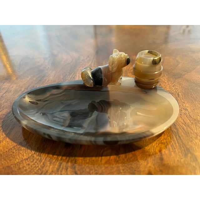 This is an extremely unique and beautiful piece. Having a deep toned black agate ashtray bowl, finely carved Pekingese dog...