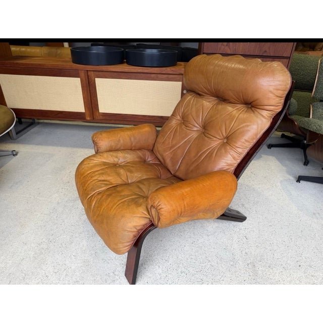 In good used condition with age related marks present. Stable and sound in construction! A rare tan leather lounge chair...