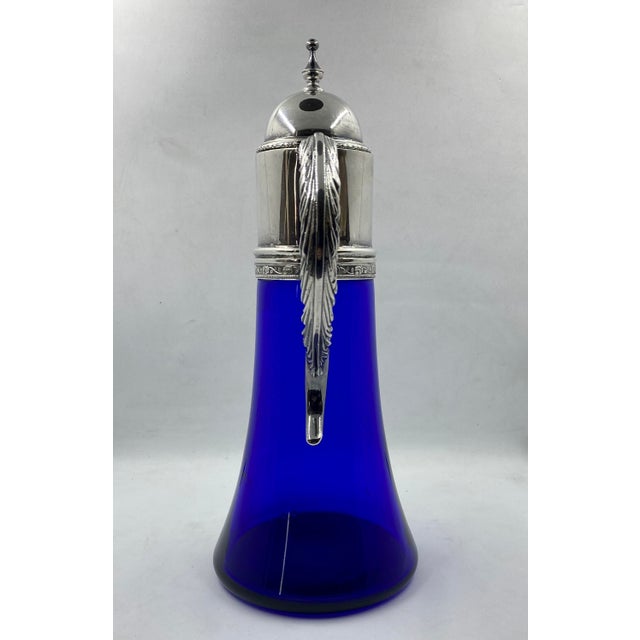 This gorgeous Austrian Cobalt blue glass pitcher has a detailed alpaca or "German silver" top. The contrast between the...
