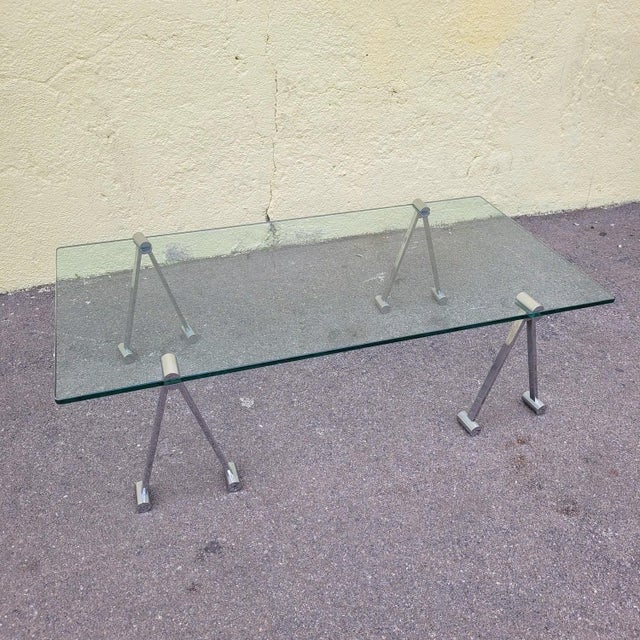 Large coffee table with an architectural and minimalist design: the rectangular, thick glass top rests stably on a system...