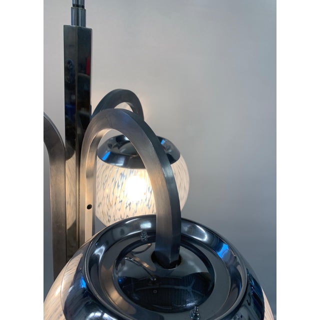 A modern pendant chandelier by Nason-Moretti, featuring a chromed metal frame characterized by elegant interwoven oval...