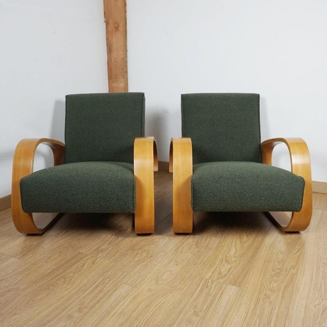 A pair of 'tank chairs 400' by alvar aalto. Beech bentwood with forest green boucle re-upholstery. Designed 1936....