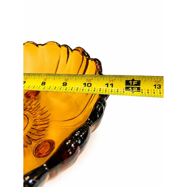 A beautiful vintage amber glass sunflower bowl featuring a bold molded floral design and a wonderfully sculptural...