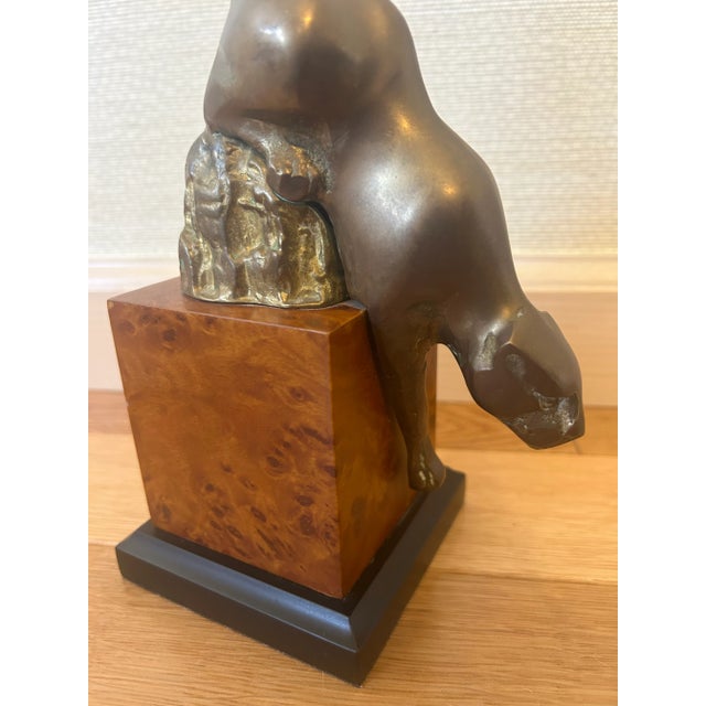 Fabulous 1970's brass mountain lion/panther bookend/objet with a faux burlwood block base. A sleek and masculine addition...