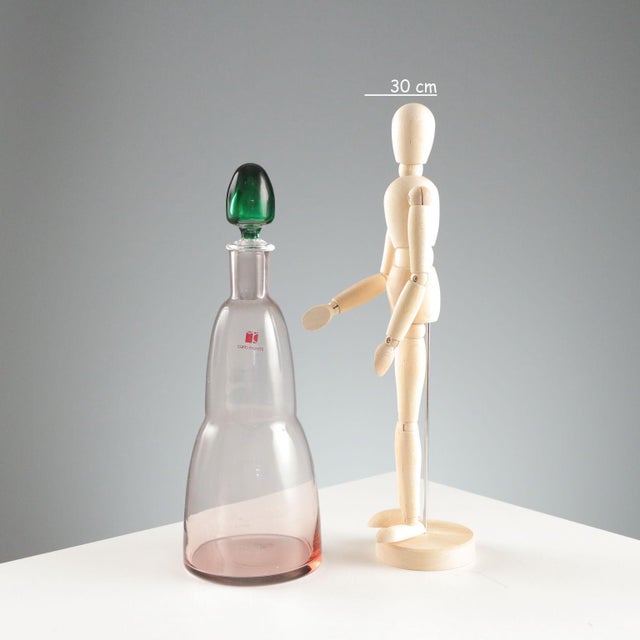 Blown glass bottle with green cap. Signature of the designer and manufacturer's sticker. Bottle height 29 cm. Original...