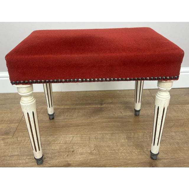 A stylish Vintage French footstool , featuring a rich red upholstered seat that adds warmth and elegance to any setting....