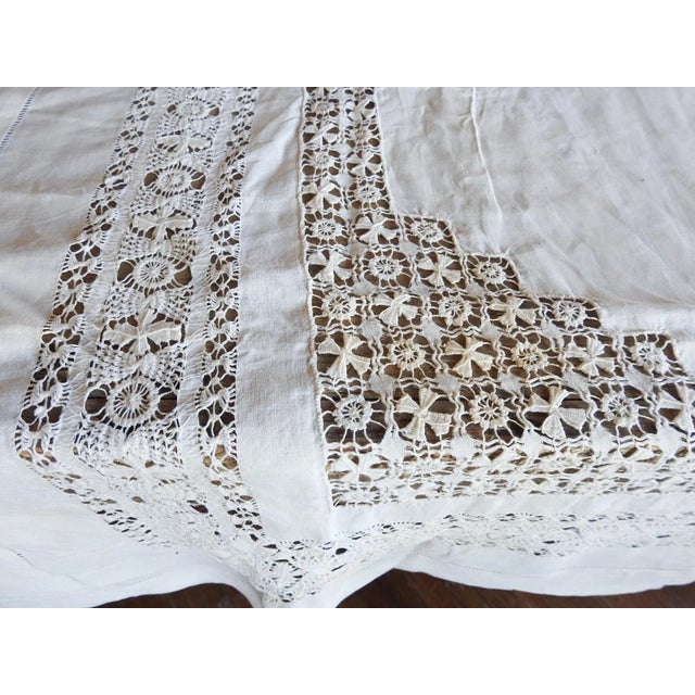Antique early 20th century white linen luncheon tablecloth with hand needle openwork. Few faint scattered spots.