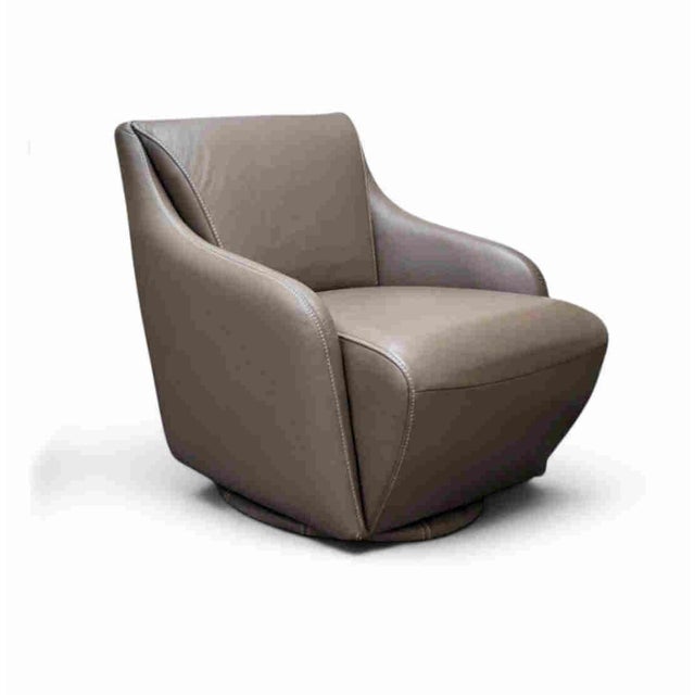 A clean contemporary Nikki leather swivel chair by W. Schillig. The chair swivels 360 degrees and rests on an upholstered...