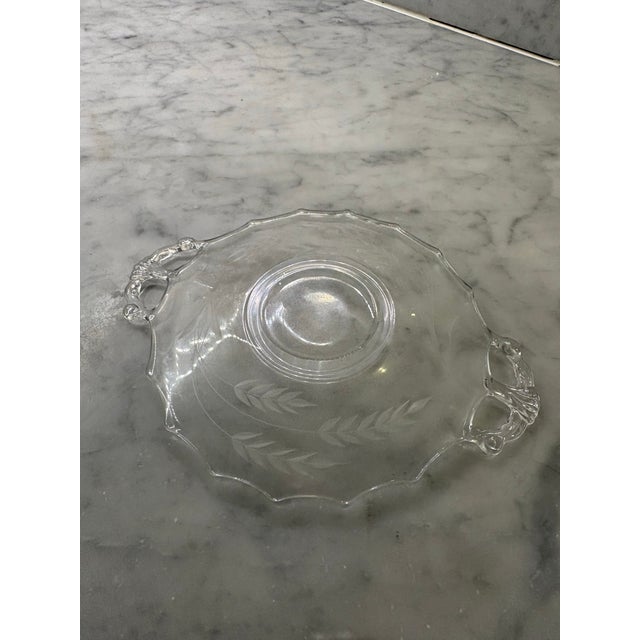 Elegant clear glass serving plate with scrolled handles. 9.5” handle to handle. 7” side to side. Delicate etched leaf...