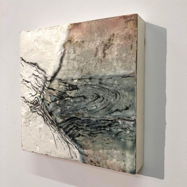 Solitude presents a textured interplay of encaustic, sumi ink, and plaster on wood, creating a serene landscape that...