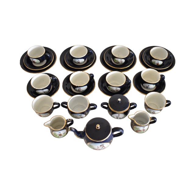An antique, 19th-century, Victorian-era child's tea service in German tole enamel, with dark blue, gilt trim, and...