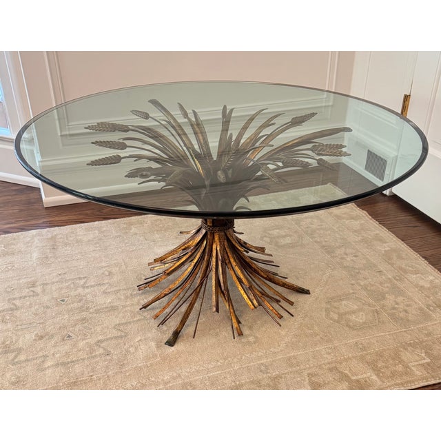 Sculptural Italian Hollywood Regency coffee table featuring an intricately detailed gilt metal wheat sheaf base with rope...