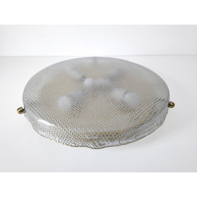 Mid-century mount ceilinglight by Hillebrandfeaturing a large textured glass shade with brass details. The molded glass...