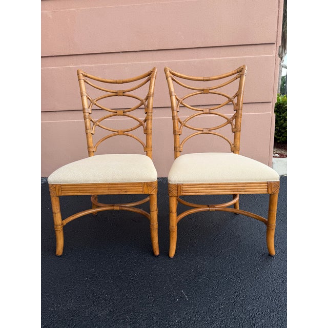 A matched pair of Lexington Tommy Bahama Beach House dining chairs featuring faux bamboo frames, open fretwork backs, and...