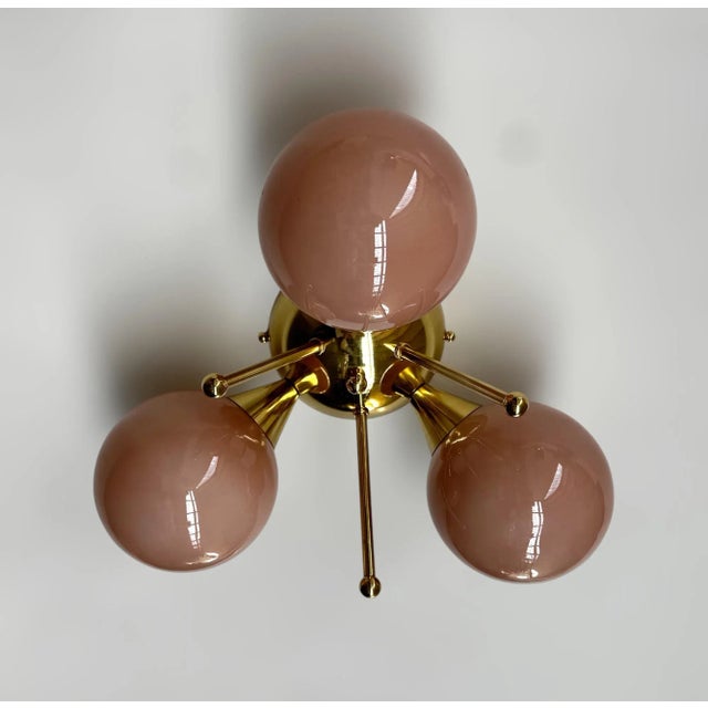 Italian flush mount with three opaque coral Murano glass globes mounted on solid brass frame in lacquered polished brass...