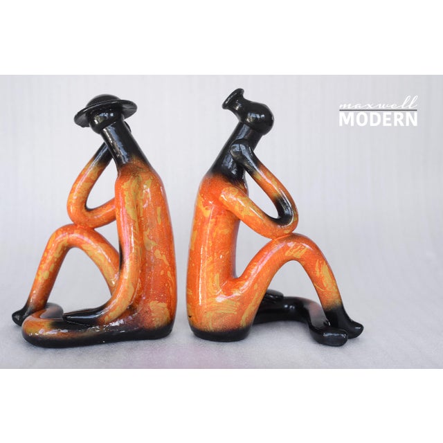 Stunning unique pair of abstract ceramic man and women sculptures with orange, yellow and black glazes. Very stylized and...