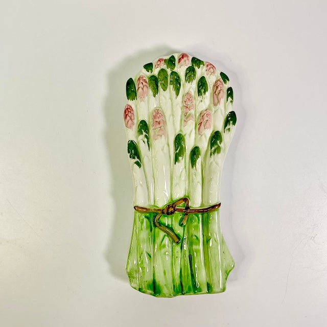 A pretty and stylish Asparagus Bunch Ceramic Spoon Rest. It features a color palette of bright green, dark green, pink and...