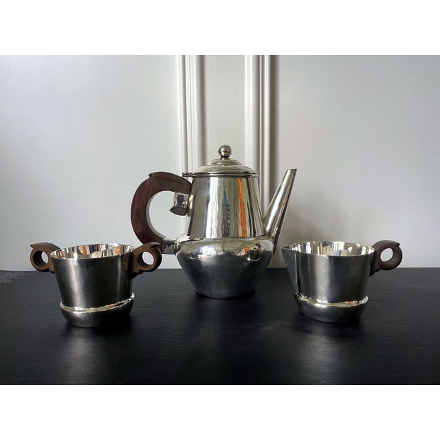 An early set of sterling silver coffee or tea set comprising a coffee or tea pot, a cream jug and an open sugar bowl....