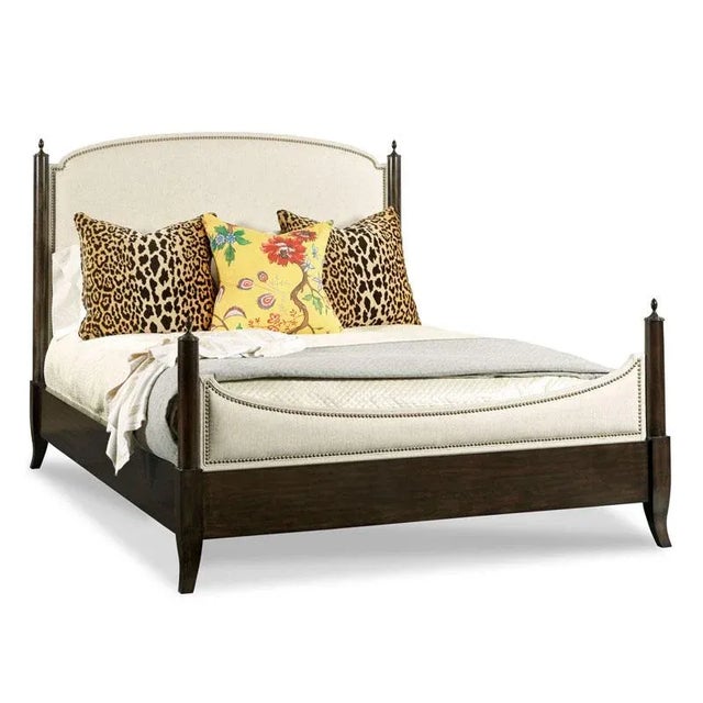 Inspired by 18th century English originals, a padded upholstered headboard with brass nailhead trim is elevated by...