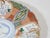 Hand painted Imari pattern plate decorated with Crain's, florals and geometric patterns. The plate has a scalloped rim...