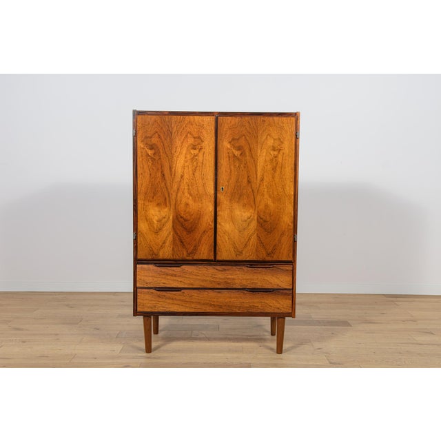 This mid century chest of drawers in rosewood was manufactured in the denmark the 1960s. The chest of drawers has 2...