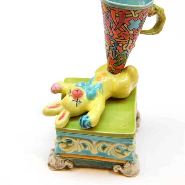 Dead Rabbit Cup with Base transforms a traditional porcelain cup into a thought-provoking sculptural object, blending dark...