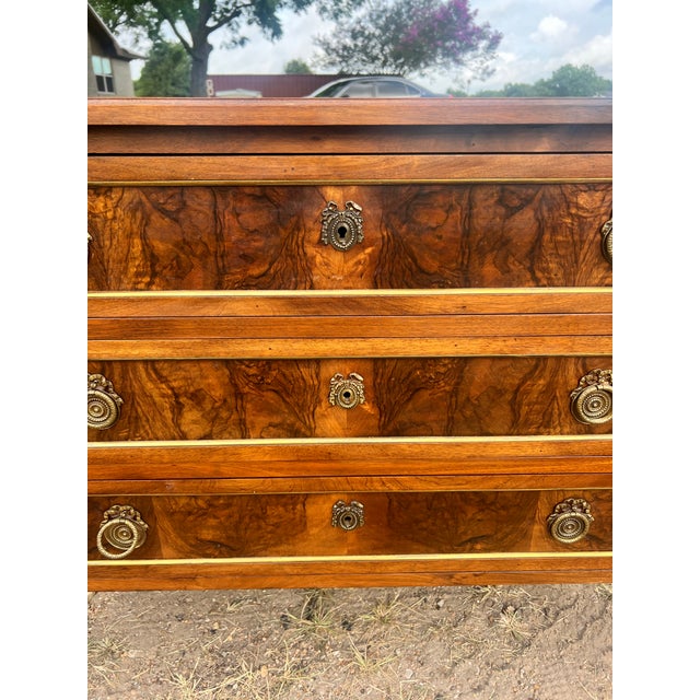 Elegant 19th-century Louis XVI style commode crafted with richly figured walnut veneer, showcasing beautiful burl wood...