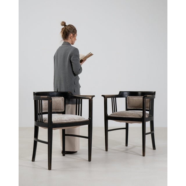 This pair of armchairs carries genuine presence, its black wood frame, caned back, dark upholstered seat immediately...